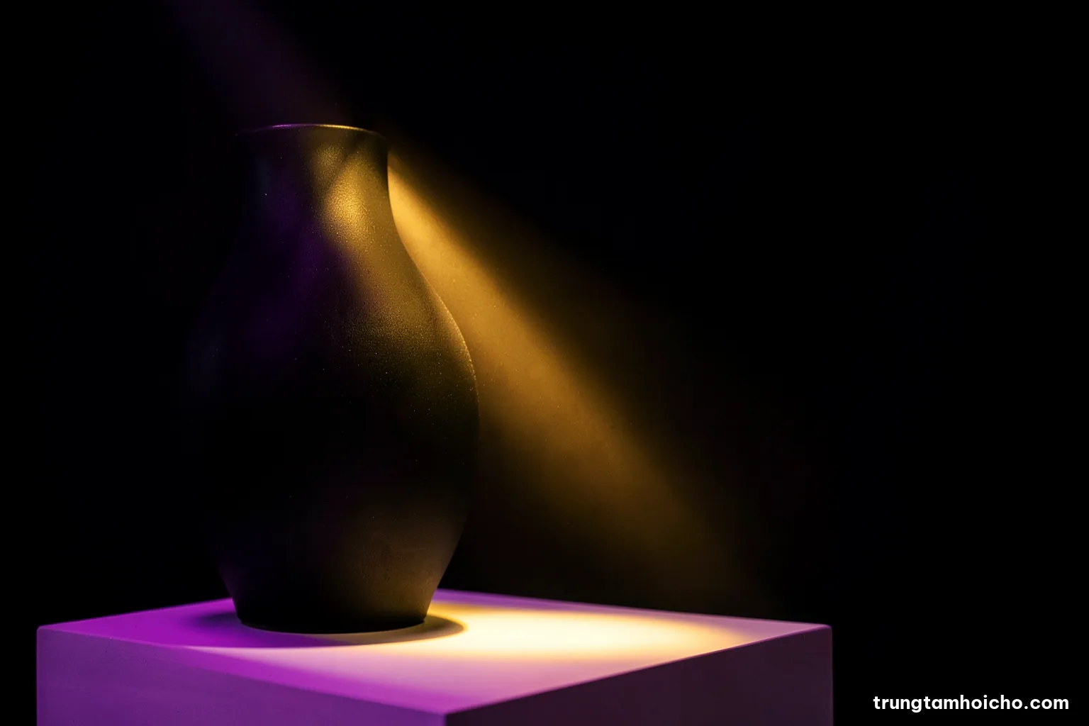 Macro shot of a matte black LED spotlight casting a narrow warm beam onto a ceramic vase on a white plinth, dark background, dramatic chiaroscuro, black and amber palette
