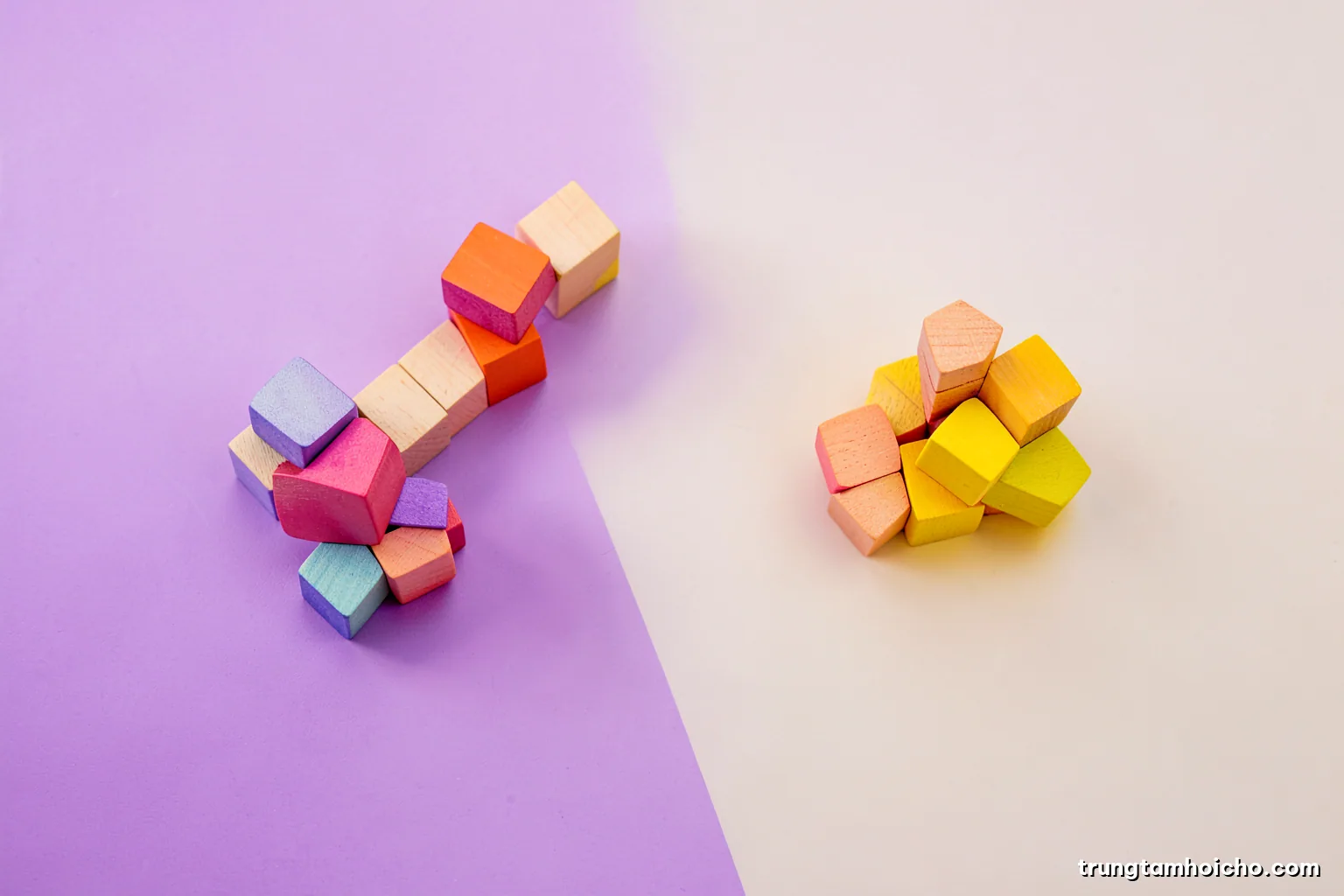 Top-down view of colourful wooden blocks arranged into separate clusters on a pale table, representing categories, soft diffused daylight, violet yellow and cream palette, minimal conceptual still life