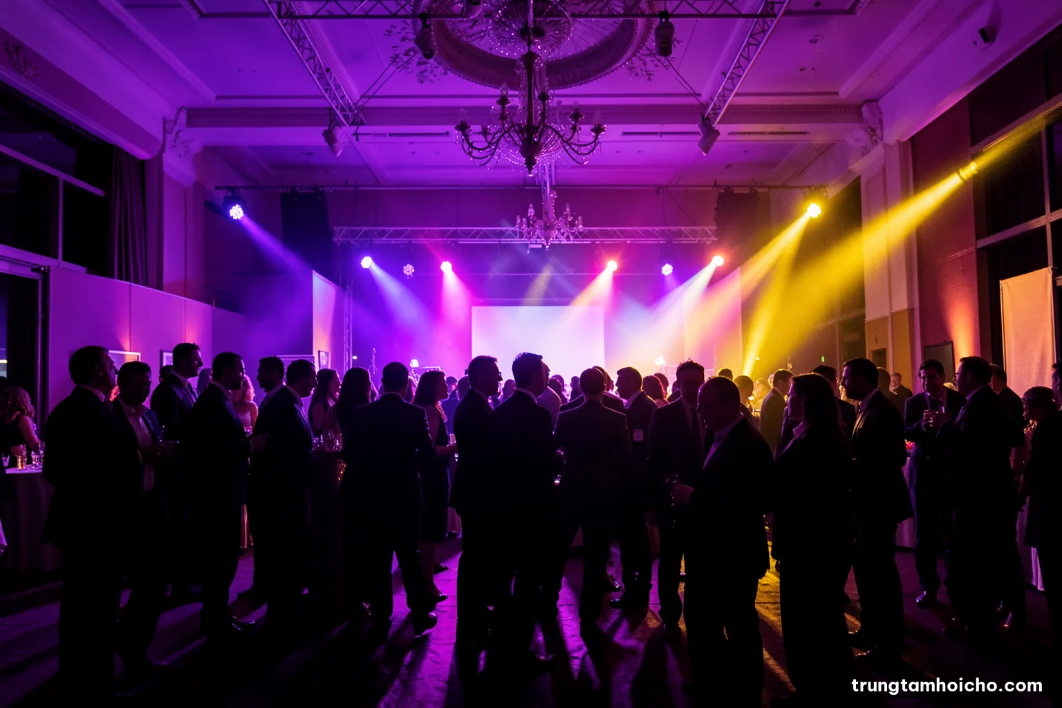 Silhouettes of guests mingling in a hotel ballroom during a product launch reception, stage lights glowing behind them, wide shot, deep violet and warm amber palette