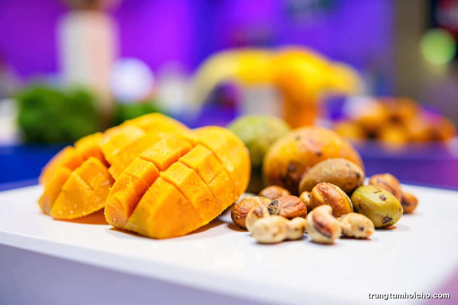 Macro close-up of tropical fruit samples, dried mango and cashew arranged on a white exhibition counter, shallow depth of field, crisp daylight, fresh green and orange palette, editorial food photography